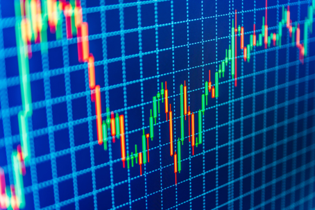 Candlestick trading chart displayed on a blue digital screen, showing intraday price movements in green and red.